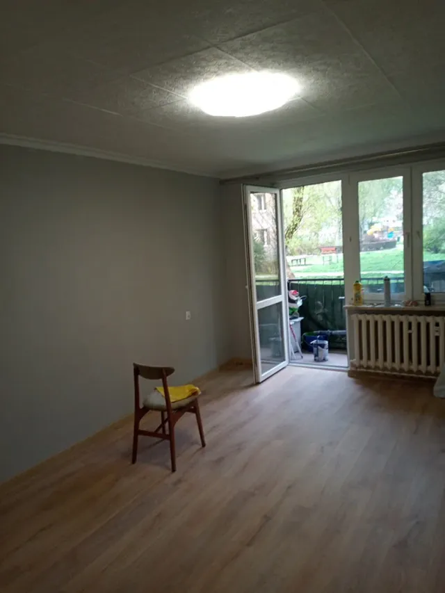 Pokój z drzwiami balkonowymi po remoncie, panele podłogowe i pomalowane ściany, realizacja w Krakowie