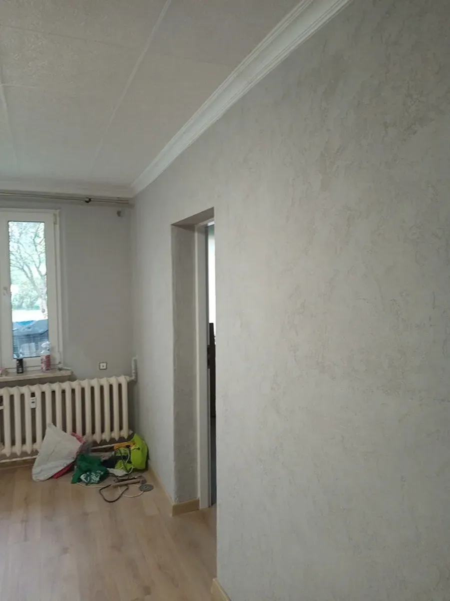 Ściana wykończona tynkiem dekoracyjnym o drobnej strukturze, realizacja w Krakowie