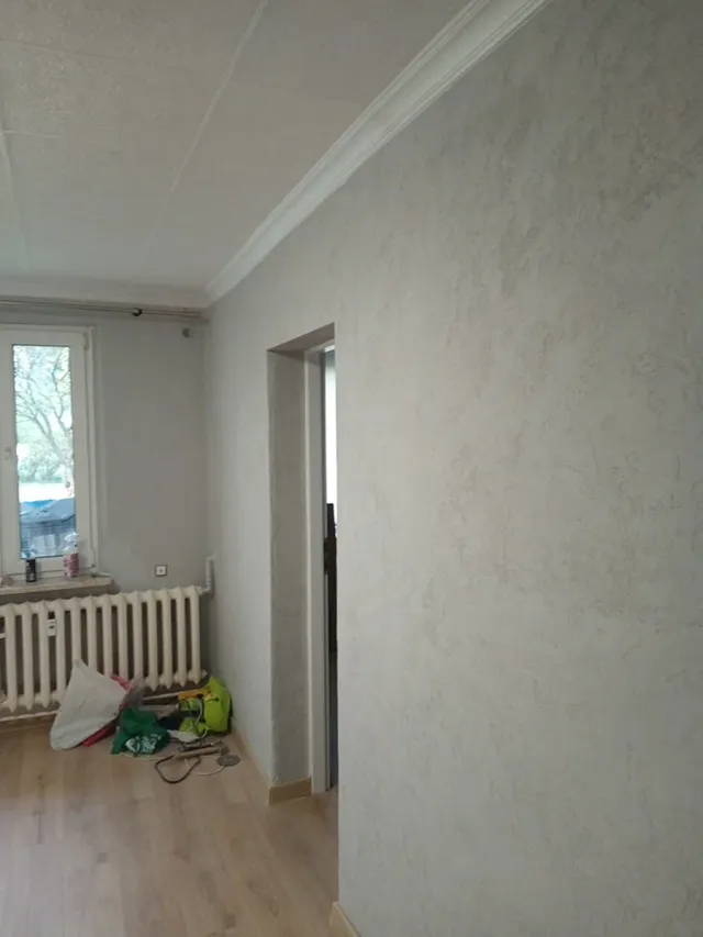 Ściana wykończona tynkiem dekoracyjnym o drobnej strukturze, realizacja w Krakowie